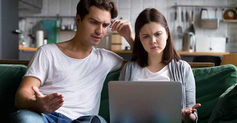 millennial couple using computer