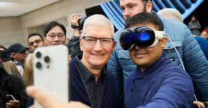 Apple CEO Tim Cook poses for a selfie with a customer wearing a Vision Pro