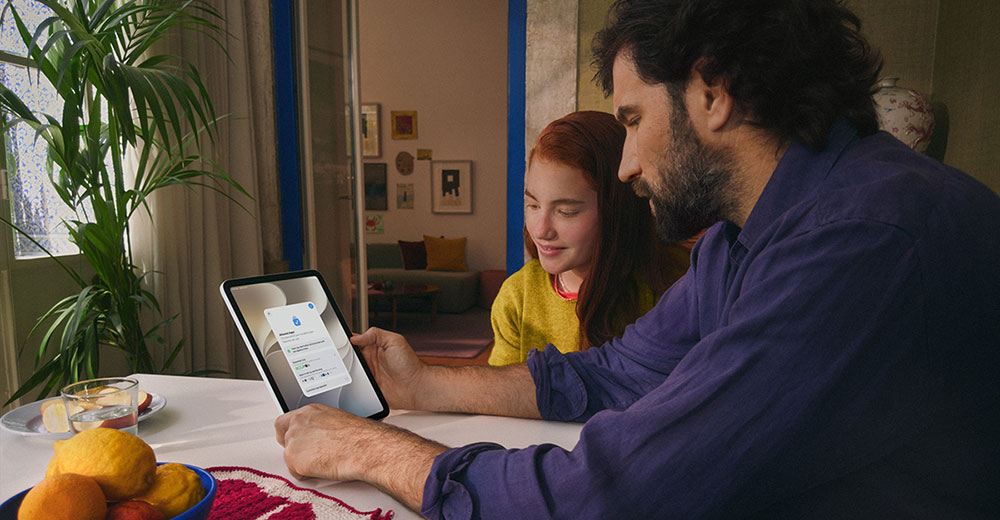 Parent and daughter review Apple's parental controls and app permissions on an iPad